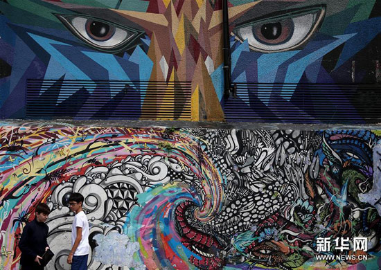 3月29日，在巴西圣保罗，两个男孩在“蝙蝠侠胡同”的一处涂鸦墙前停留。