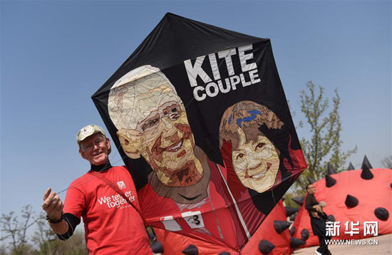 一名来自美国的风筝爱好者在展示印有自己和夫人头像的风筝。 一名来自美国的风筝爱好者在展示印有自己和夫人头像的风筝。