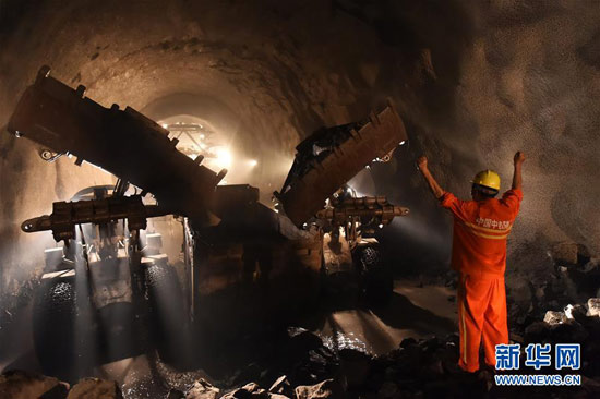 7月16日,工人在隧道贯通点指挥车辆清运石方。 7月16日,工人在隧道贯通点指挥车辆清运石方。