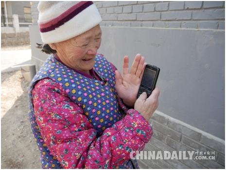村民闻老太向记者展示手机里自己拍摄的花展照片 李雪晴/摄 村民闻老太向记者展示手机里自己拍摄的花展照片 李雪晴/摄