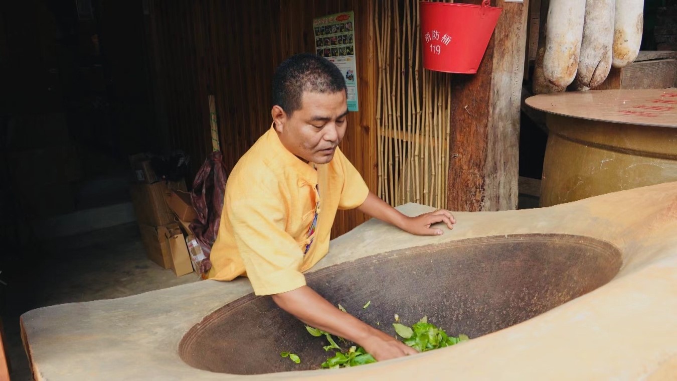 San Wen roasts fresh tea leaves at home. Yang Jinghao/CGTN