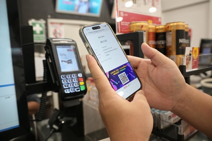 A customer makes a payment by scanning a local NETS QR code with WeChat Pay at a shop in Singapore, April 23, 2026. (Photo by Then Chih Wey/Xinhua)