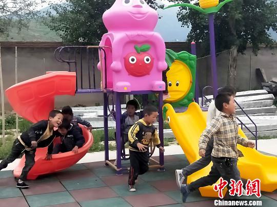 图为哇龙小学的孩子在捐赠的滑梯上玩耍。　李隽 摄