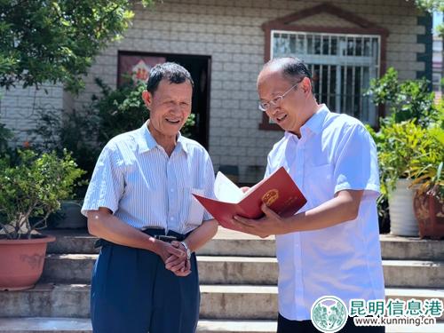 西山区委副书记、区长陈瑞斌（右）为农户送去农村土地承包经营权证。1
