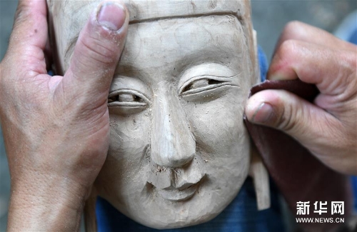 方文展在打磨一块毛南族傩面