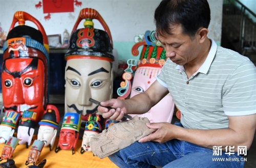 方文展在雕刻毛南族傩面