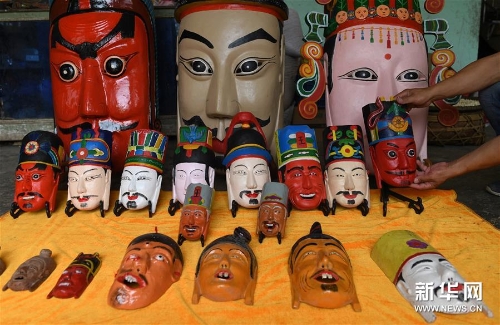 方文展在家里整理自己的毛南族傩面作品