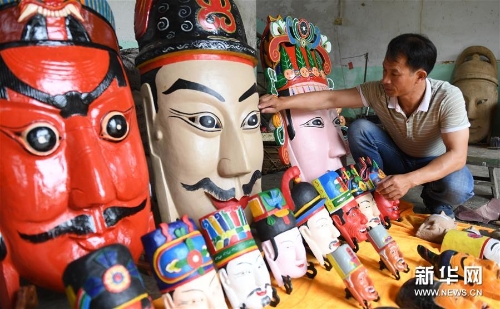 方文展在整理自己制作的毛南族傩面作品