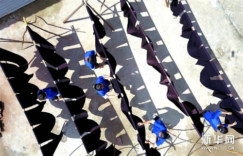 侗家妇女在鼓楼旁晾晒侗布 侗家妇女在鼓楼旁晾晒侗布