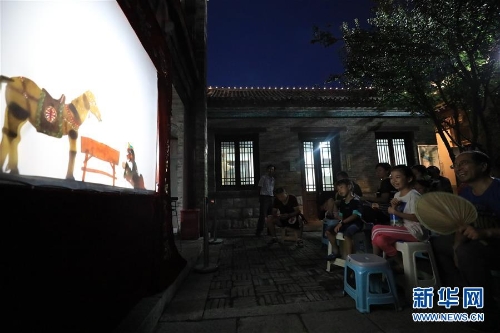 李卫在济南百花洲为市民表演皮影戏(7月15日摄)。 李卫在济南百花洲为市民表演皮影戏(7月15日摄)。