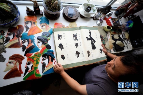 李卫展示自己制作的“济南名人脸谱”系列的皮影人偶。 李卫展示自己制作的“济南名人脸谱”系列的皮影人偶。