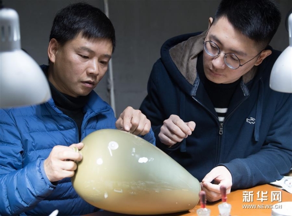 龙泉青瓷艺术家杨盛侃(右)将一件有瑕疵的作品带到吴荣强的工作室,跟他讨论漆缮修复的细节。 龙泉青瓷艺术家杨盛侃(右)将一件有瑕疵的作品带到吴荣强的工作室,跟他讨论漆缮修复的细节。
