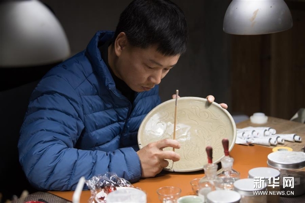 吴荣强在龙泉市牛头岭村“七分醉”工作室对一件青瓷器皿进行漆缮 吴荣强在龙泉市牛头岭村“七分醉”工作室对一件青瓷器皿进行漆缮