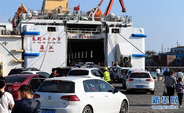 2月9日，在海口秀英港内的紫荆二十二号客滚船上，小车和旅客有序上船。