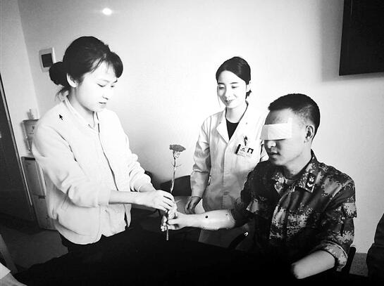 杜富国进行肌电手抓握训练,将一朵花送给妻子王静。 杜富国进行肌电手抓握训练,将一朵花送给妻子王静。