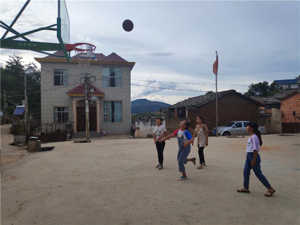 孩子们在汤家保老人倡议修建的篮球场上打球。