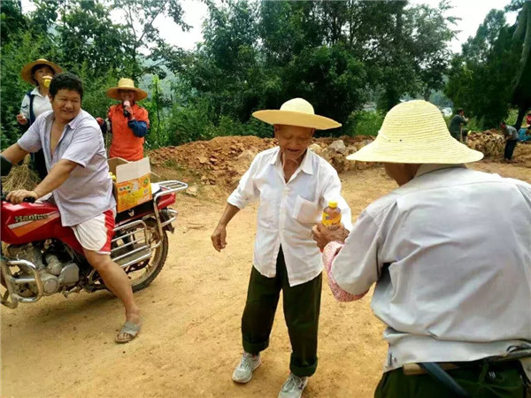 热心的汤家保给村民送饮料。.webp