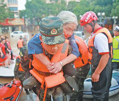 8月11日，浙江临海，武警救援人员将一位受困老人转移到安全地区。影像中国