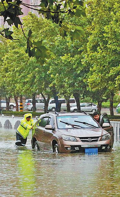 8月11日，山东枣庄，交警在积水中救助受困车辆。 孙中喆摄（新华社发）