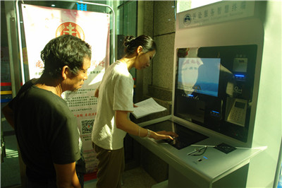 法院工作人员指导前来立案的群众使用自助终端