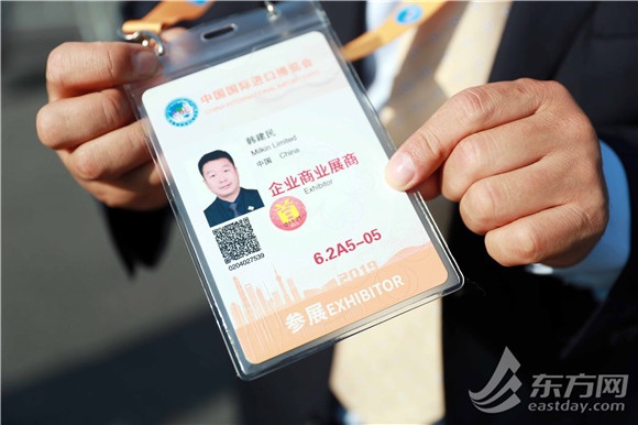 图片说明:参展商展示自己的证件。