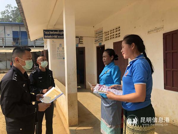 班相果民警陈明宏和战友在老挝驻地的班赛中学，发放防疫宣传单。