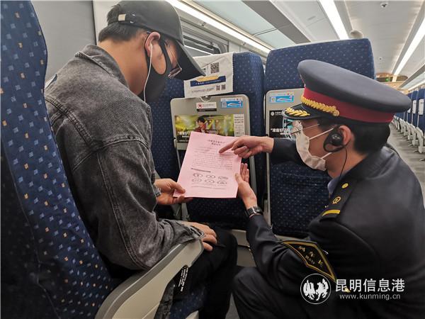 在昆明南至玉溪的C8421次列车上，乘务员和旅客共同学习法律知识。杨洁 摄