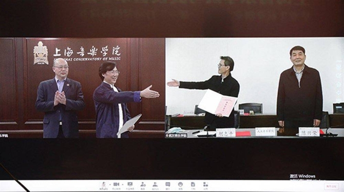 图片说明:上海音乐学院、武汉音乐学院两位院长签约现场“云握手”