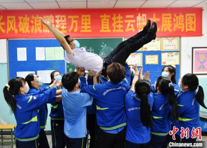 图为同学们将老师举高抛起，表达着自己对老师的感谢之情。　翟羽佳 摄