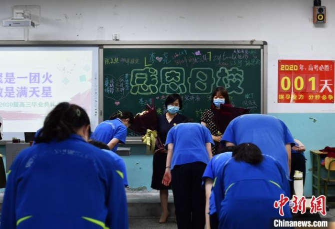 图为同学们向教授他们知识的老师鲜花，并深深的鞠躬。　翟羽佳 摄