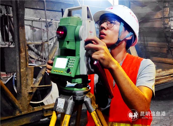 中铁十二局集团施工人员在隧道内进行测量作业。