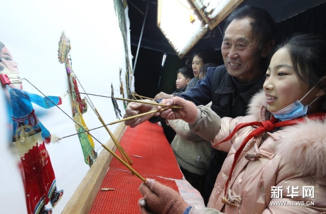 12月15日,在位于河南省许昌市建安区苏桥镇的河南省润知非物质文化遗产研学旅行基地,许昌陈氏皮影第四代传人陈志国(右二)指导学生学习皮影戏。新华社发(牛书培 摄) 12月15日,在位于河南省许昌市建安区苏桥镇的河南省润知非物质文化遗产研学旅行基地,许昌陈氏皮影第四代传人陈志国(右二)指导学生学习皮影戏。新华社发(牛书培 摄)