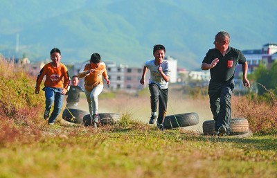 江西省萍乡市麻田中心学校，学生们在进行“轮胎赛跑”训练。 新华社发