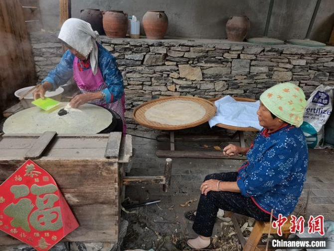 村民正在制作煎饼。上官云 摄 点击进入下一页