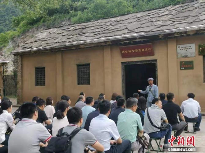 图为北梁村老党员杜天祥在为游客义务讲解。 <a target='_blank' href='http://www.chinanews.com/' >中新网</a>记者 谢艺观 摄 点击进入下一页