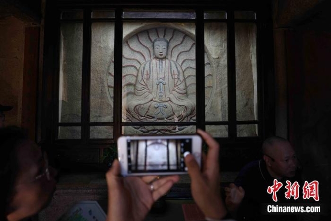 7月9日,泉州草庵摩尼光佛造像吸引参观者拍摄。蒋启明 摄 点击进入下一页