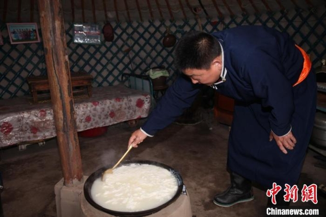 图为多年前，贷庆在蒙古包里制作传统奶食品。　受访者供图