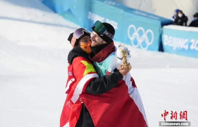 图为苏翊鸣(左)与马克斯·帕罗特拥抱。中新社记者 毛建军 摄