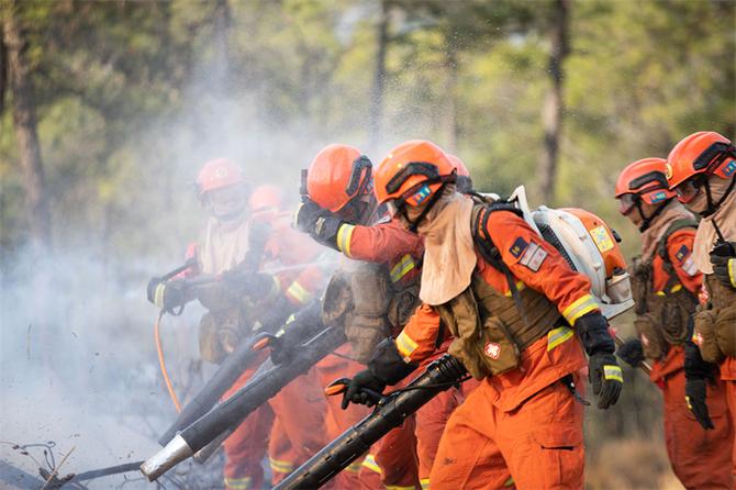 12.灭火机手用手挡住火场浓烟对眼睛带来的伤害,水枪手为灭火队员洒水降温 12.灭火机手用手挡住火场浓烟对眼睛带来的伤害,水枪手为灭火队员洒水降温