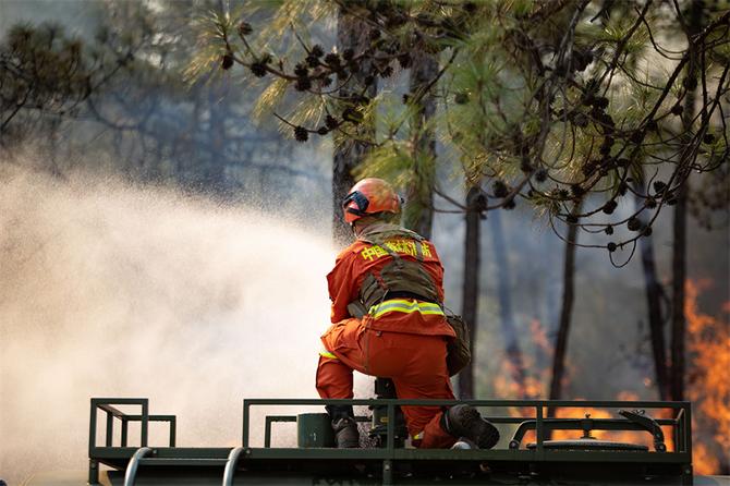 21.消防员在水罐车顶利用水枪压制火势 21.消防员在水罐车顶利用水枪压制火势
