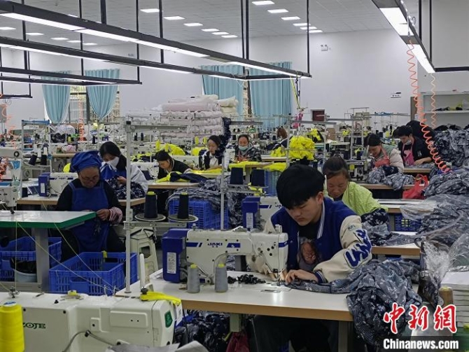 搬迁民众在制衣工厂工作。 石小杰 摄 搬迁民众在制衣工厂工作。 石小杰 摄