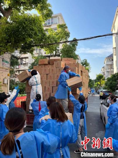 图为志愿团队在为居民分发物资。 受访者供图