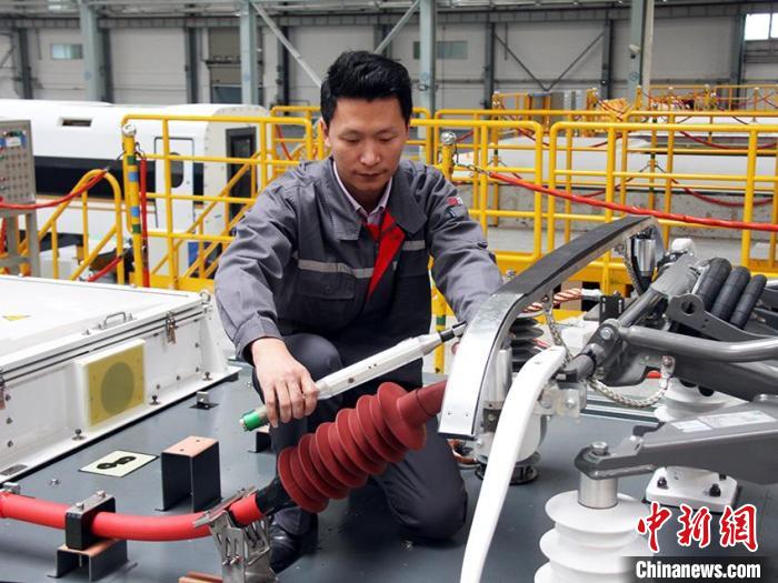 胡俊祥在连接车顶高压电缆。 受访者本人供图 胡俊祥在连接车顶高压电缆。 受访者本人供图