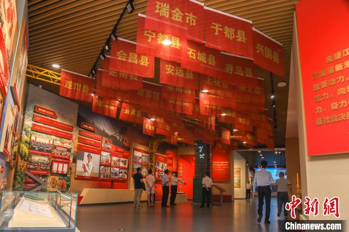 图为展厅内悬挂的印有赣南等原中央苏区各县市区名字的旗帜。　刘力鑫 摄