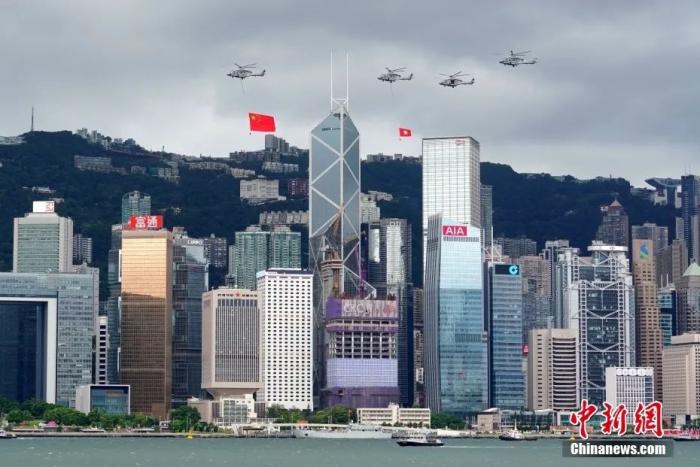 7月1日早晨，香港特区政府庆祝香港回归祖国25周年升旗仪式在金紫荆广场举行，分别悬挂五星红旗和香港区旗的直升机编队飞过维港上空。中新社记者 张炜 摄