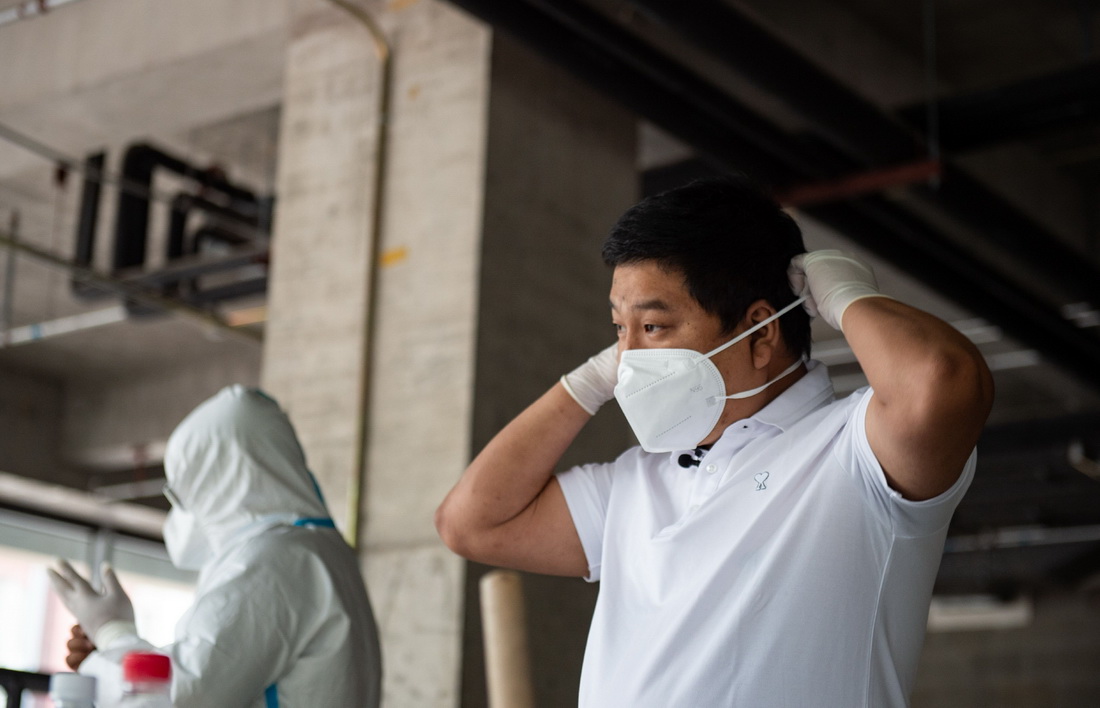 6月3日,张旭在进行志愿服务前穿戴防护装备。新华社记者 陈钟昊 摄
