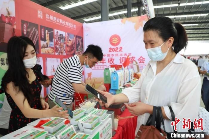 在睢河街道展台,游客扫码付款,再留个联系方式,好吃再买。 顾士刚 摄 在睢河街道展台,游客扫码付款,再留个联系方式,好吃再买。 顾士刚 摄