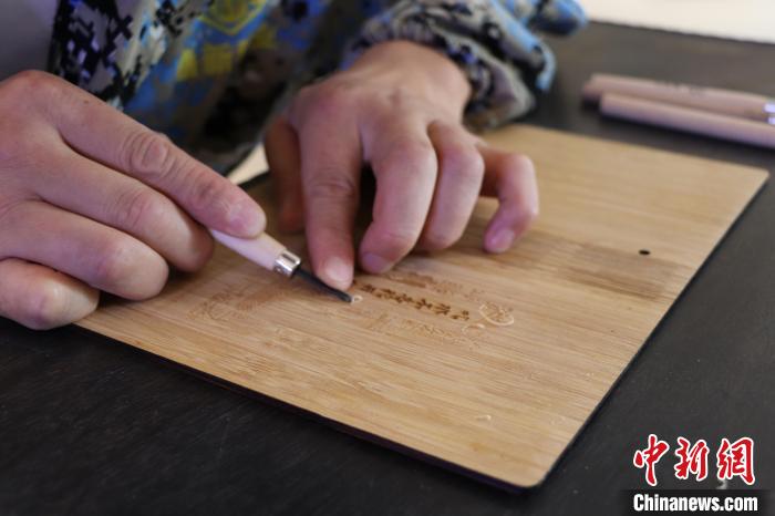 图为陈艳华正在楠竹上雕刻。 刘玉洁 摄 图为陈艳华正在楠竹上雕刻。 刘玉洁 摄