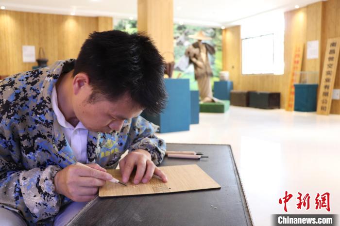 图为陈艳华正在楠竹上雕刻。 刘玉洁 摄 图为陈艳华正在楠竹上雕刻。 刘玉洁 摄
