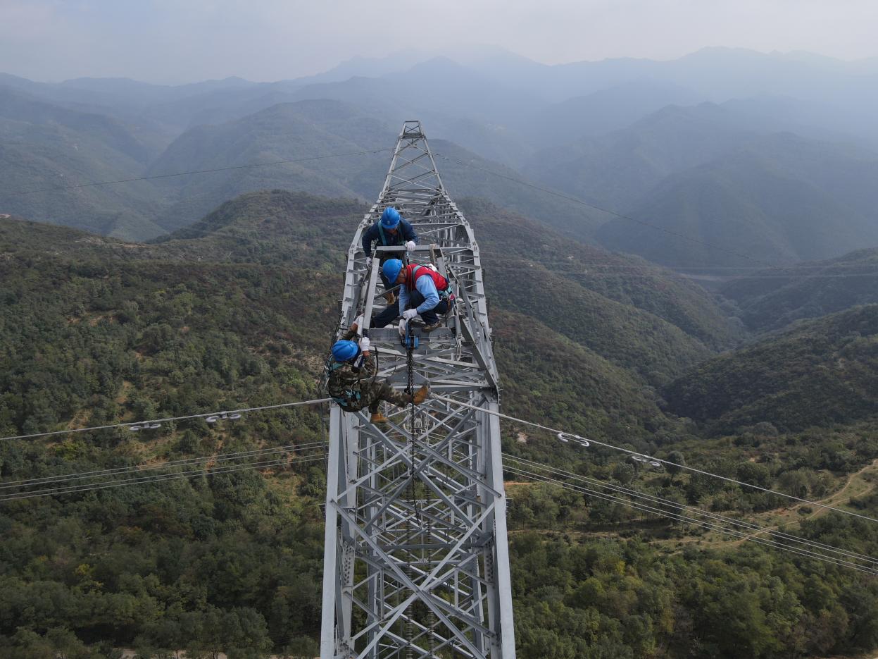 70米高的铁塔，郝晨飞与队员们在塔顶进行作业。（图片由国网山西超高压输电公司提供）